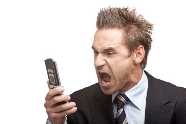 Businessman has stress and sreams into mobile phone