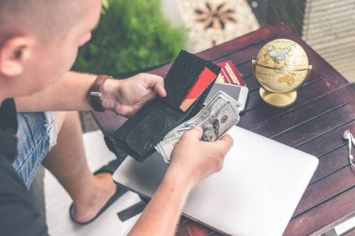 man looking at his wallet money