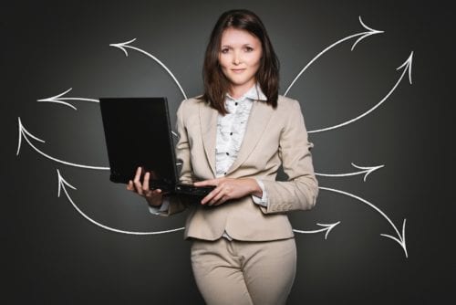 A woman using a laptop surrounded by arrows