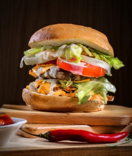 Large cheese burger with lots of toppings