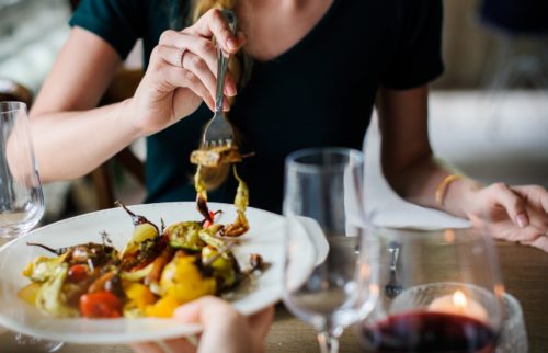 A woman eating dinner, face not shown