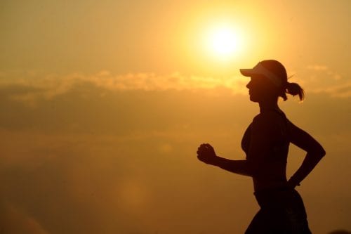 Shot of a woman running at sunset