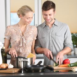 A happy couple cooking together in the kitchen