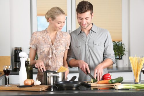 A happy couple cooking together in the kitchen