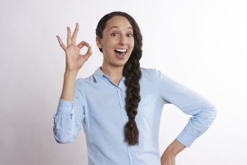 A woman signaling A-OK with her hand