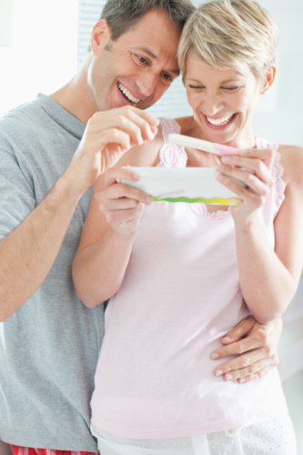 Happy couple holding a pregnancy test