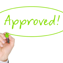 A hand writing and circling the word "Approved"