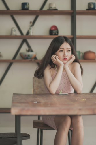 A bored asian woman sitting at a desk